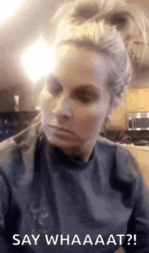 a woman with a mask on her face is saying " say whaaat "