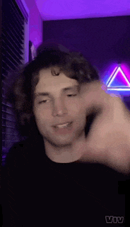 a young man is making a funny face in front of a purple light .
