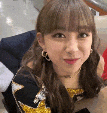 a close up of a woman wearing earrings and a choker that says ' a ' on it