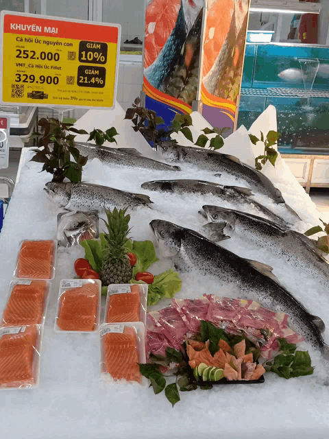 a sign that says khuyen mai sits above a display of fish