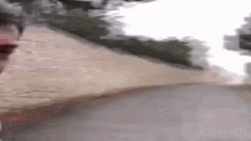 a man is walking down a sidewalk with a dog behind him .