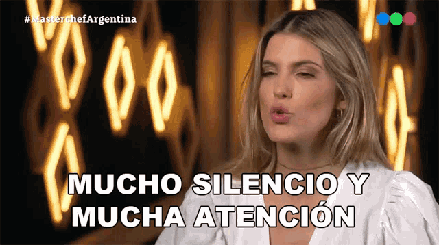 a woman says mucho silencio y mucha atencion in front of neon lights