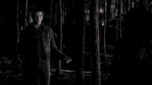 a man in a suit and tie is holding a bloody hand in the dark