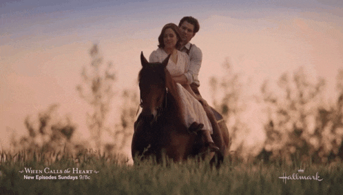 a man and woman are riding a horse in a field with the words when calls the heart