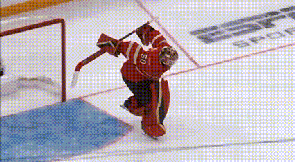 a hockey goalie wearing a red jersey with the number 50 on it