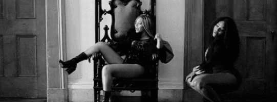 a black and white photo of a woman sitting on a throne .
