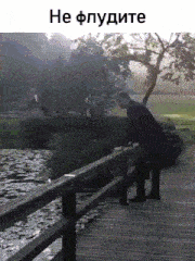 a man in a suit is standing on a bridge over a body of water .
