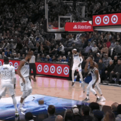 a basketball game is being played in front of a state farm ad