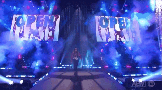 a person walking down a stage with a sign that says " open "