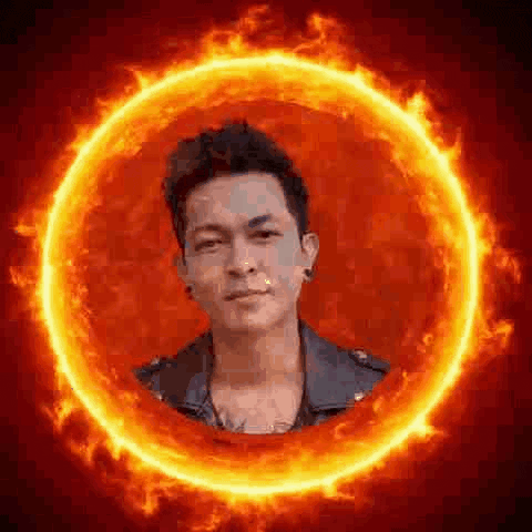 a man is standing inside of a circle of fire .