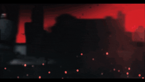 a blurred image of a person in a dark room with a red background