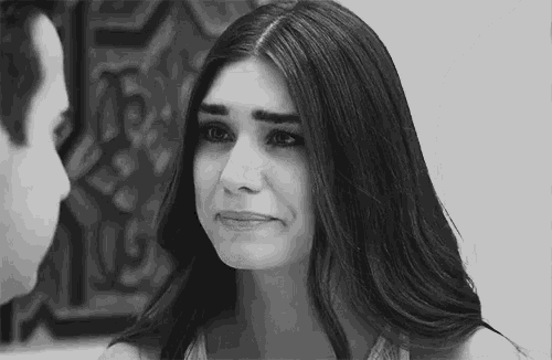 a black and white photo of a woman crying while looking at a man .