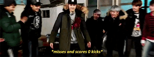 a group of young men are standing in a room and one of them says " misses and scores 0 kicks " .