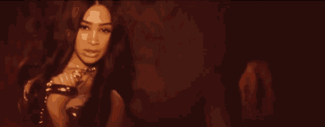 a woman with long hair is standing in a dark room looking at the camera