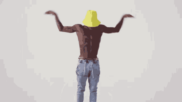 a shirtless man wearing a yellow hat and jeans is dancing