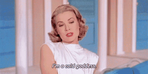 a woman in a white shirt is sitting on a couch and saying `` i 'm a cold goddess '' .
