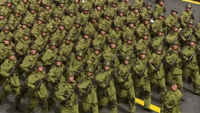 a large group of soldiers marching in a line with their guns