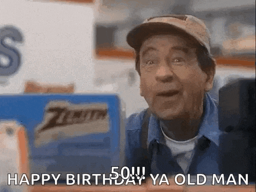 a man in a hat is sitting in front of a computer and saying `` happy birthday ya old man '' .