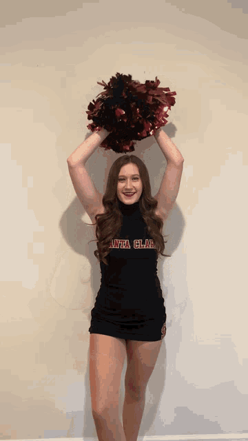 a cheerleader wearing a black sweater that says uta clae