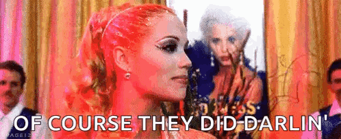 a woman with red hair is saying `` of course they did darlin '' in front of a group of people .