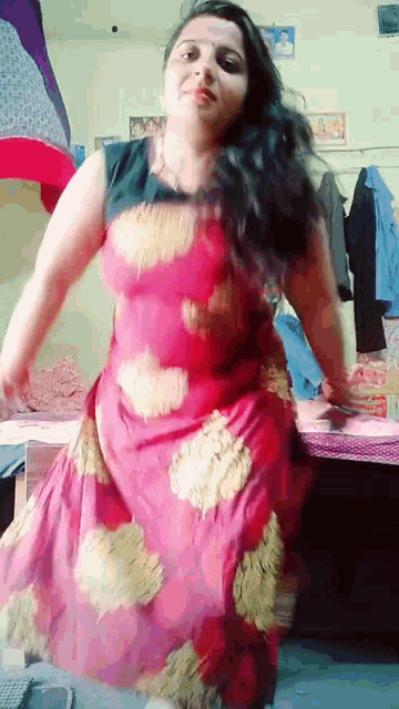 a woman in a long red dress is dancing in a bedroom