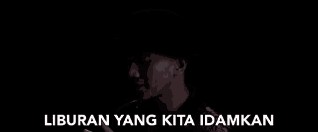 a woman 's face is visible in the dark with the words liburan yang kita idamkan written below her .