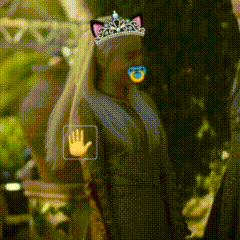 a woman wearing a cat ear tiara with a pacifier in her mouth .