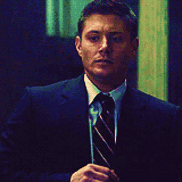 a man in a suit and tie stands in a doorway