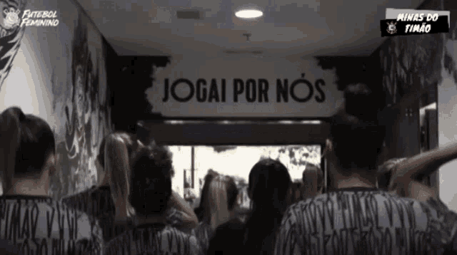 a group of people are standing in front of a sign that says jogai por nos