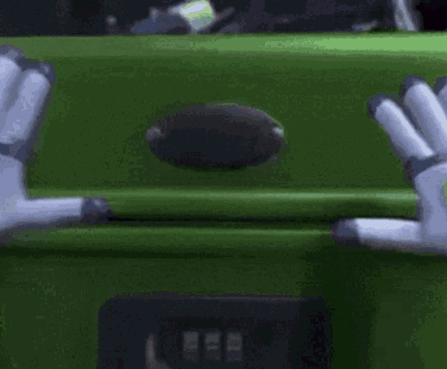 a close up of a toy story character 's hands reaching out towards a green box .