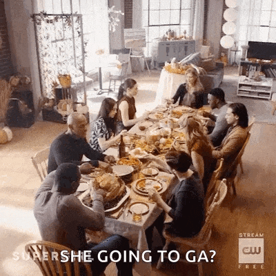 a group of people are sitting at a long table eating food and talking .