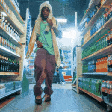 a man wearing a hooded jacket is walking through a store