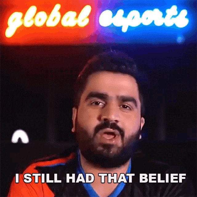 a man says " i still had that belief " in front of a neon sign that says global esports