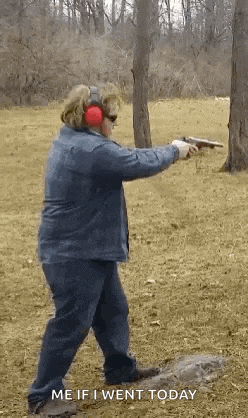 a woman wearing ear muffs is pointing a gun at the camera .