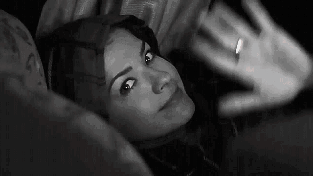a woman is laying on a bed looking at her phone .