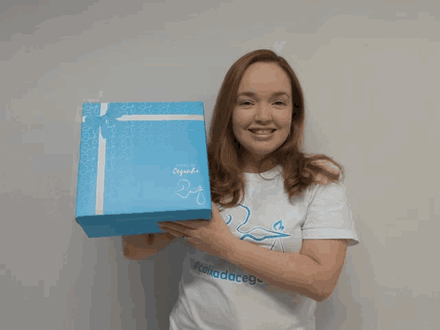 a woman holding a blue box that says pampers
