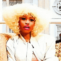 a woman with blonde hair is sitting on a couch wearing a white jacket and hat .