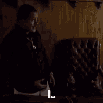 a man in a black jacket is standing in front of a chair with the words beat the below him