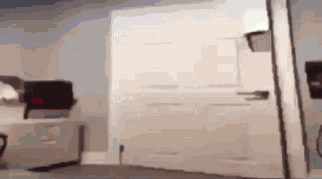 a blurred image of a room with a white door and a chair