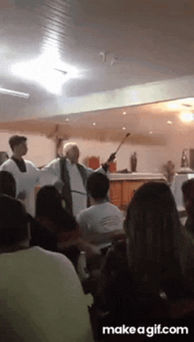 a priest is giving a sermon in front of a crowd of people