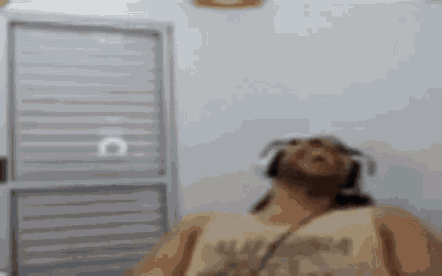 a man wearing headphones and a tank top is sitting in a room .