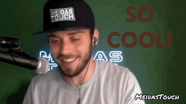 a man wearing a meidas touch hat is smiling