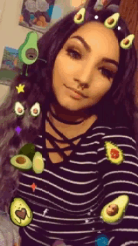 a woman wearing a black and white striped shirt with avocados on her hair