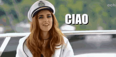 a woman is wearing a captain 's hat and smiling while sitting on a boat .