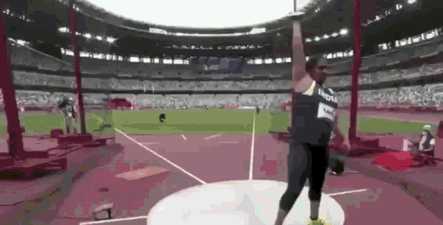 a man is throwing a discus in a stadium while wearing a shirt that says nokia .