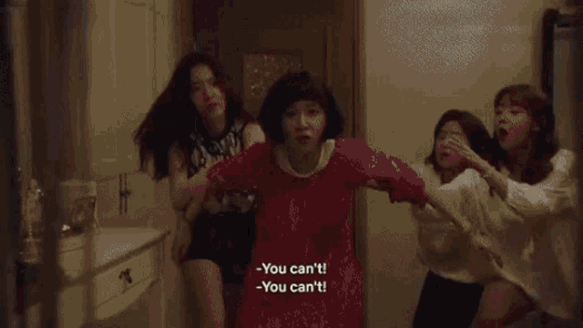 a group of women are standing next to each other in a hallway .