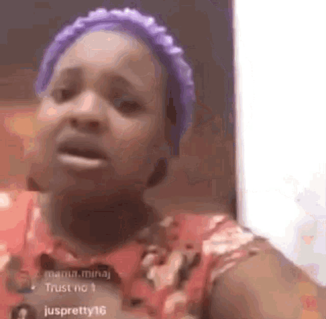 a woman with purple hair and a purple headband is making a funny face .