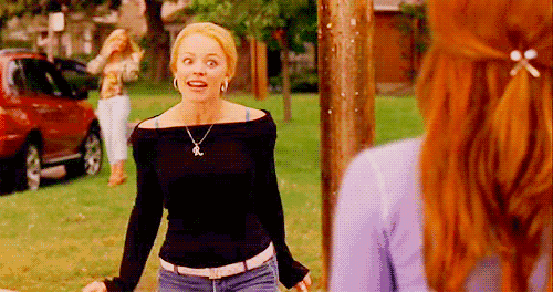 a woman in a black off the shoulder top is standing next to a woman in a purple shirt .