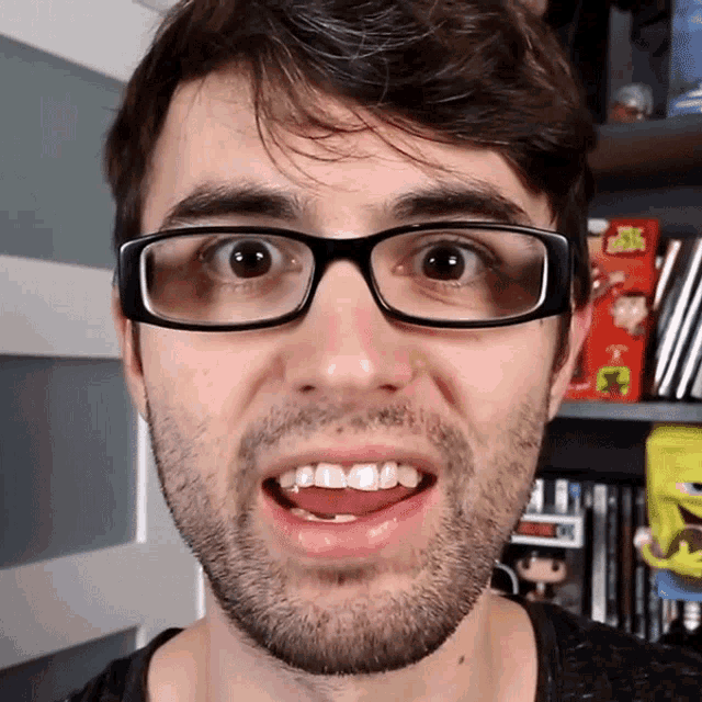 a man wearing glasses is making a funny face in front of a box that says spongebob on it