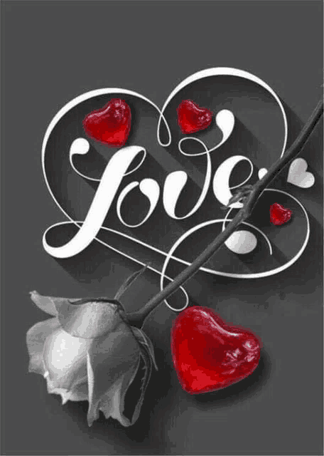 a black and white photo of a rose and red hearts with the word love written on it .